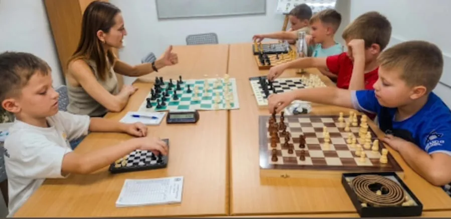ילדים משחקים שחמט והמדריכה לידם